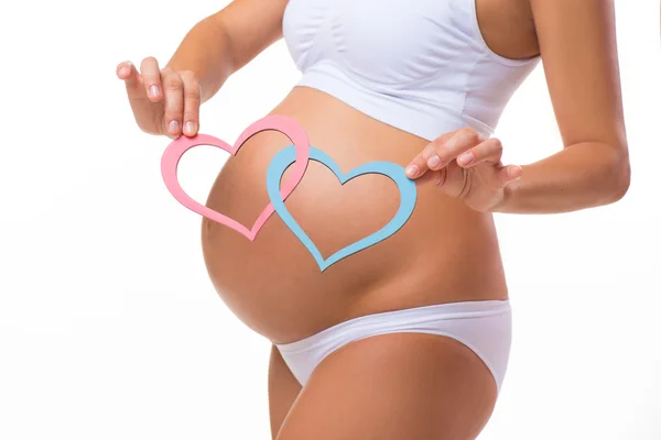 Pregnant belly with blue and pink heart. Horizontal closeup. Determine the sex of the child: twins, girl or boy.