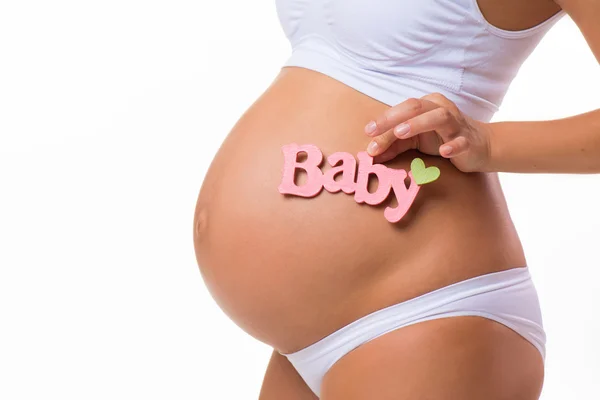 Ventre enceinte avec inscription rose pour bébé fille. Une femme enceinte attend une fille. Gros plan horizontal isolé sur fond blanc . — Photo