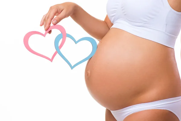 Pregnant belly with blue and pink heart. Horizontal closeup. Determine the sex of the child: twins, girl or boy.