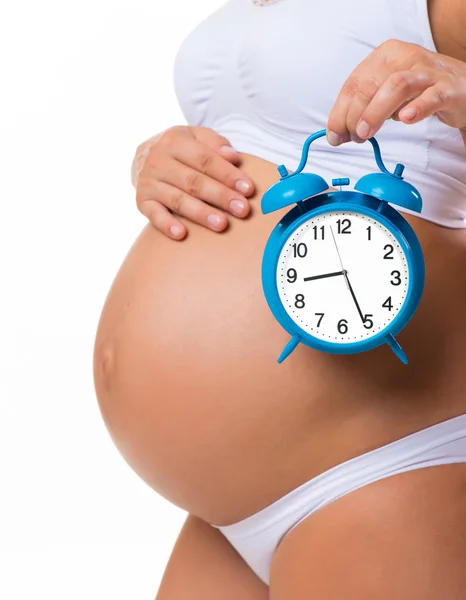 Pronto nacerá. Vientre embarazada con despertador. Imagen conceptual del embarazo feliz . — Foto de Stock
