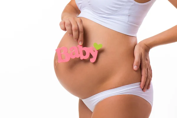 Gravid mage med rosa inskrift för flicka. Gravid kvinna väntar en dotter. Närbild horisontella isolerad på vit bakgrund. — Stockfoto