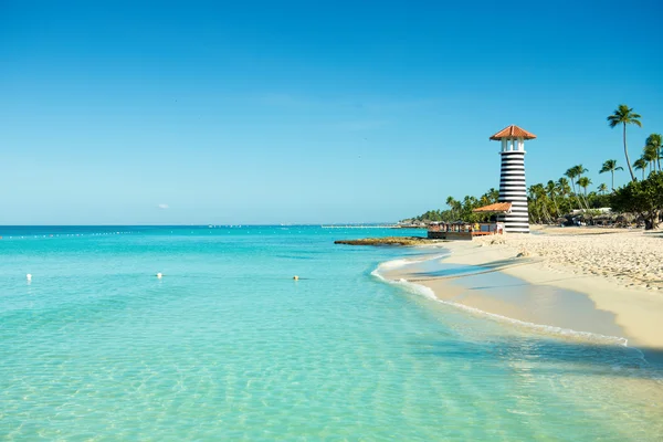 Paradise Caribbean landschap. Heldere zee, wit zand, tropische palmbomen en vuurtoren op zanderige kust — Stockfoto