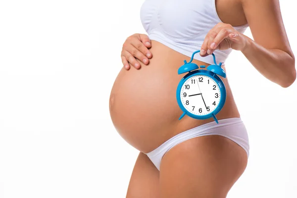 Gravid mage med väckarklocka. Konceptuella bild. Snart födelse. Fostrets utveckling av månader — Stockfoto