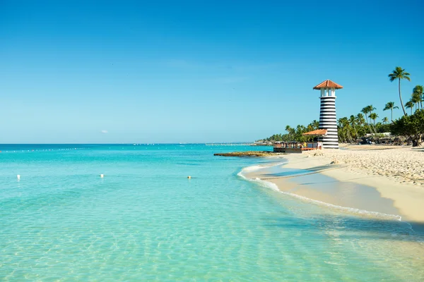 Paradise Caribbean landscape. Clear sea, white sand, tropical palm trees and lighthouse on sandy shore — Stock Photo, Image