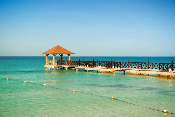 Dead Calm. Wooden pier, turquoise sea, blue horizon and clear cloudless sky. — Stock Photo, Image