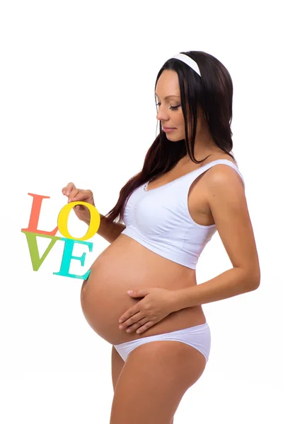 Label Amore nelle mani di una donna incinta isolata su sfondo bianco verticale — Foto Stock