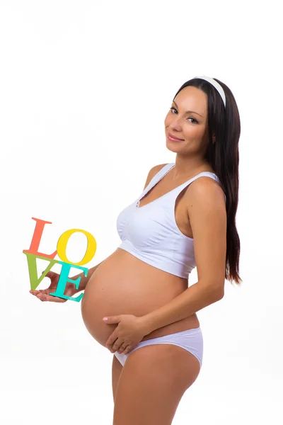 Étiquette Amour dans les mains de la femme enceinte isolé sur fond blanc vertical — Photo