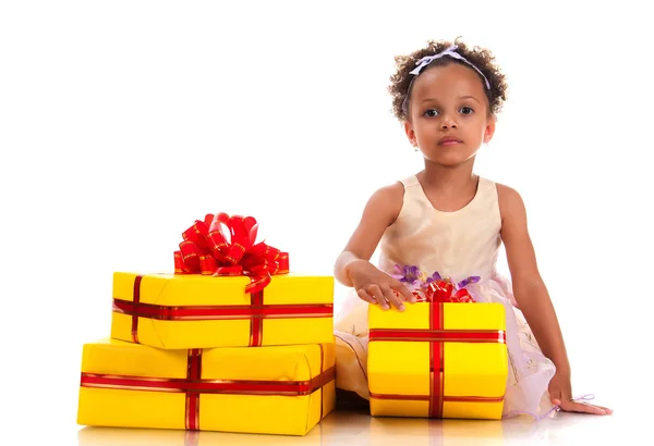 Time to give presents! Young girl with curly hair and yellow gift box on white background. — Stockfoto