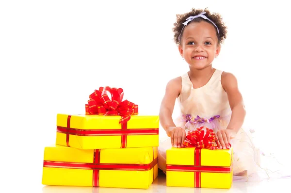 Time to give presents! Young girl with curly hair and yellow gift box on white background. — Stockfoto