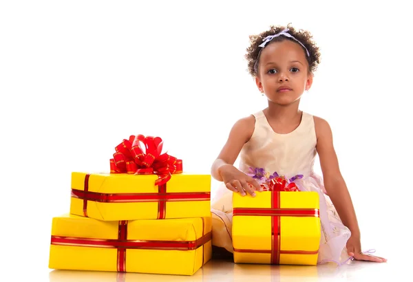 Time to give presents! Young girl with curly hair and yellow gift box on white background. Royalty Free Stock Images