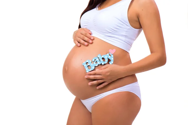 Närbild av gravid mage med blå etikett "Baby" för nyfödda pojke. — Stockfoto