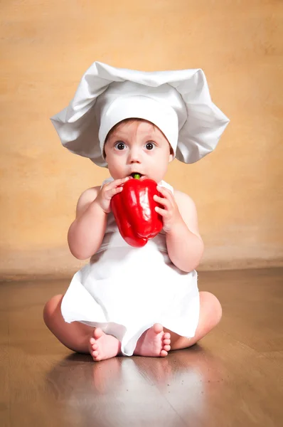 Comida saudável. Chef pequeno surpreso com pimenta vermelha na mão . — Fotografia de Stock