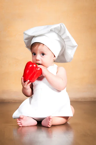 Comida saludable. Pequeño chef sorprendido con pimiento rojo en la mano . — Foto de Stock