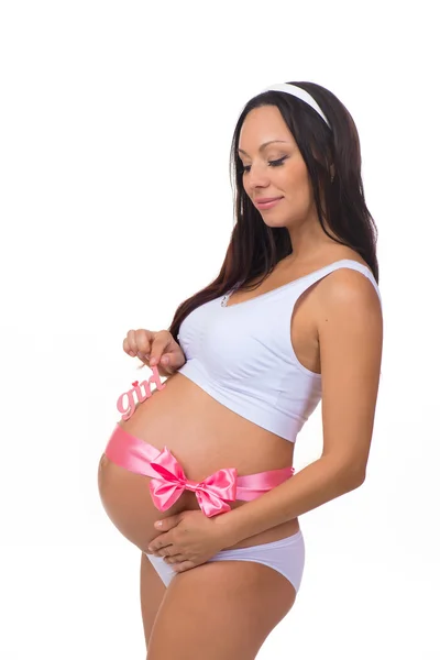 Feliz mujer embarazada con lazo de cinta rosa. Género de un niño - niña recién nacida —  Fotos de Stock