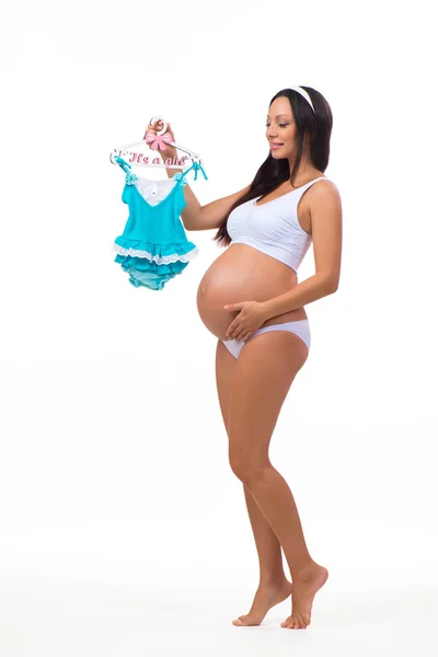 Femeie gravidă într-o rochie full-length cu rochie pentru copii pentru nou-născuți — Fotografie, imagine de stoc