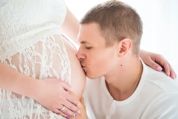 Sağlıklı mutlu hamilelik. Sarılma ve karısının yakın çekim portre hamile karnına öpüşme kocası