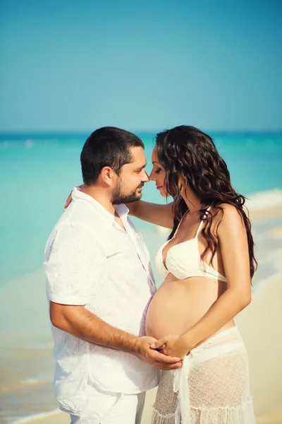 Un tânăr fericit și o femeie însărcinată pe coasta mării. Frumos cuplu îndrăgostit. Luna de miere, doar căsătorit — Fotografie, imagine de stoc
