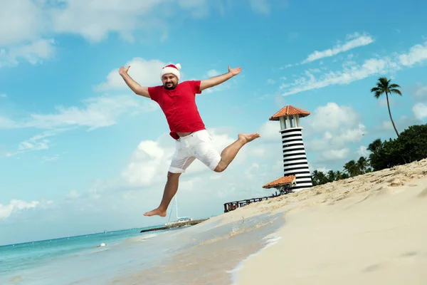 Санта Клаус і побажання щасливого нового року. Забавні Діда Мороза стрибає на морі. Тропічних піщаний пляж - різдвяні подорожі відпустку знижок та туристичних агентств Ціна скорочення концепції — стокове фото