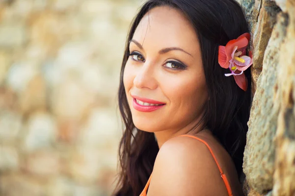 Ritratto di bella ragazza dai capelli scuri sorridente sullo sfondo di edifici medievali in pietra nella città di Altos de Chavon, Repubblica Dominicana — Foto Stock