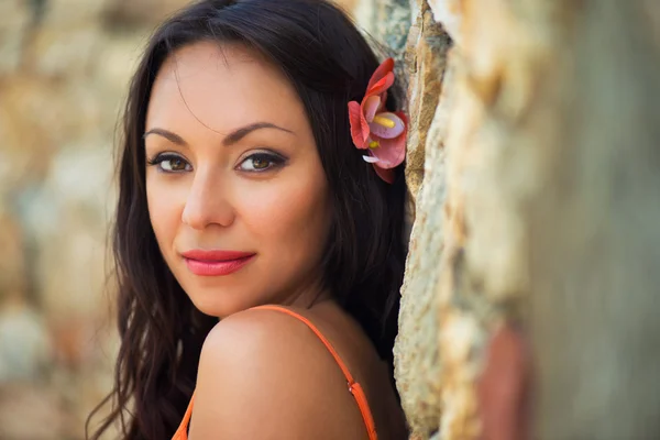 Ritratto di bella ragazza dai capelli scuri sorridente sullo sfondo di edifici medievali in pietra nella città di Altos de Chavon, Repubblica Dominicana — Foto Stock