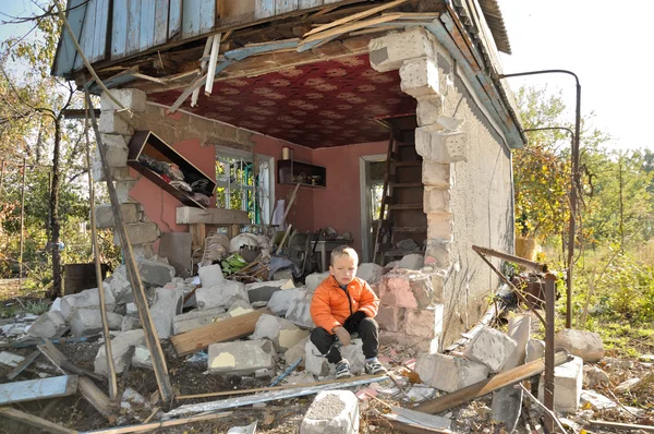 Chlapec za domkem bombardovali out. Ukrajina — Stock fotografie