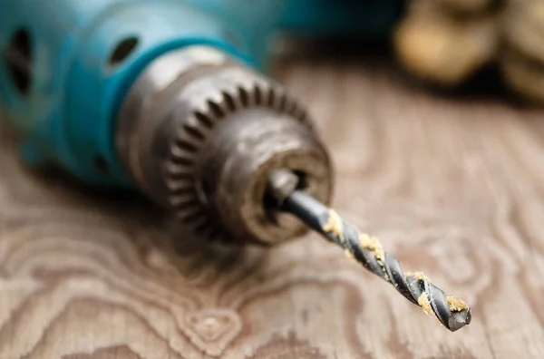 Power drill on wood with focus on drill bit