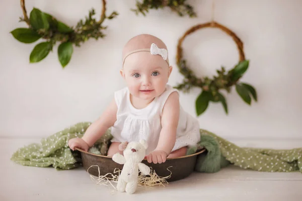 Uma Menina Vestido Branco Arco Senta Uma Tigela Lata Fundo — Fotografia de Stock