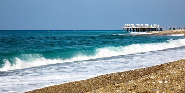 Wellen und steiniger Strand im Ferienort Alanya in der Türkei — Stockfoto