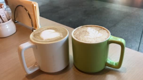 Două cești de cappuccino pe o masă într-o cafenea — Videoclip de stoc