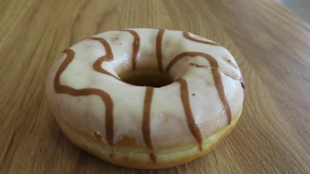 Donut vitrificado com chocolate em uma mesa de madeira — Vídeo de Stock