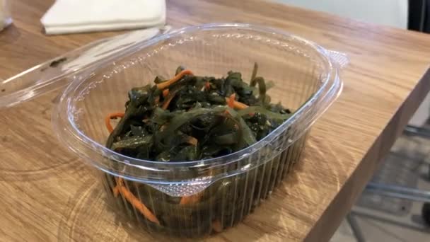 Insalata di alghe con carote in un contenitore di plastica usa e getta in un fast food — Video Stock