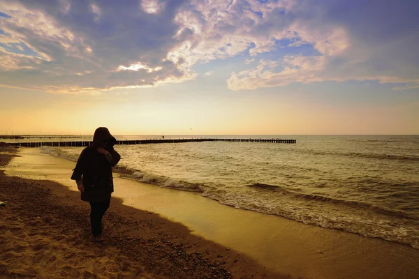 Kvinna på solnedgången på stranden — Stockfoto