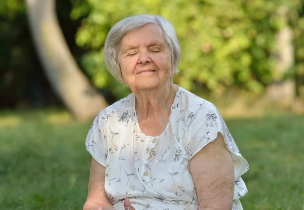 Senior vrouw die lacht in park — Stockfoto