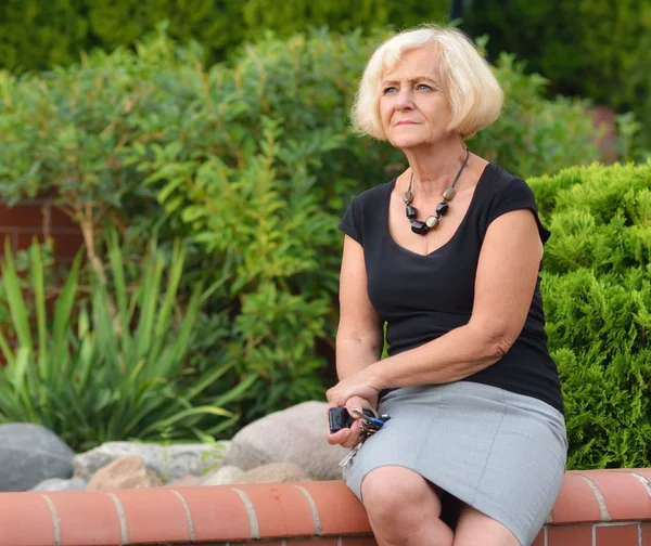 Reife, blonde frau im garten — Stockfoto