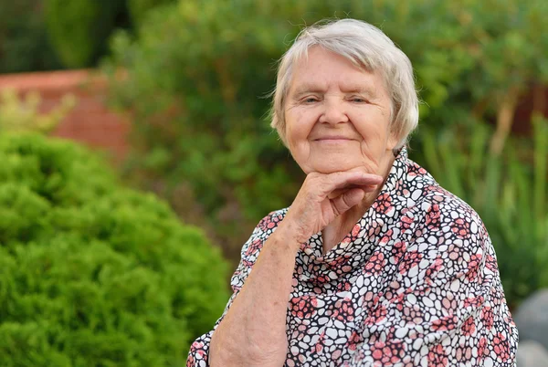 Senior vrouw die lacht in tuin — Stockfoto