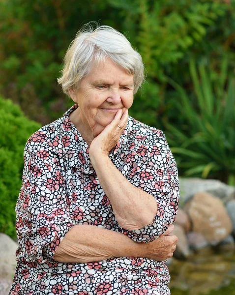 Senior mulher sorrindo no jardim — Fotografia de Stock