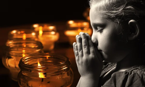 Praying child with candles — Stock Photo, Image