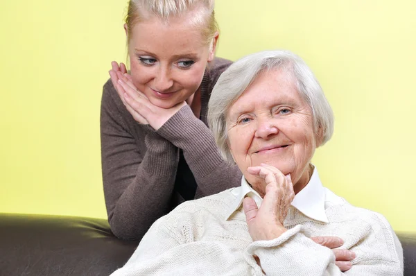 Äldre kvinna med sin vårdgivare. Glad och leende. — Stockfoto