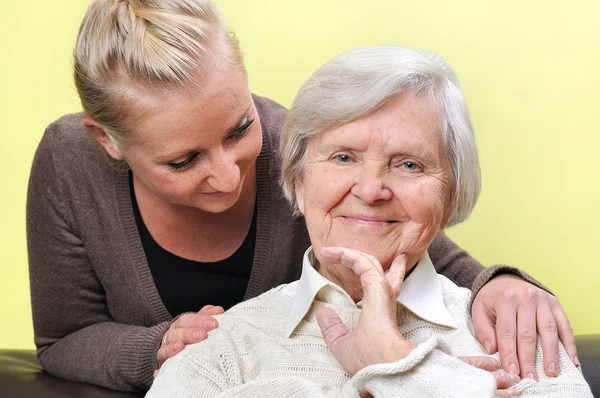 Seniorin mit ihrer Betreuerin. glücklich und lächelnd. — Stockfoto
