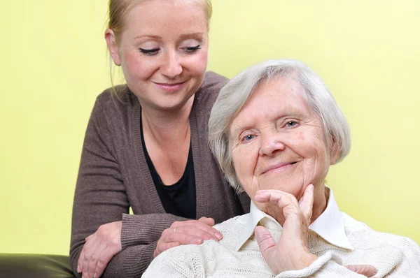 Äldre kvinna med sin vårdgivare. Glad och leende. — Stockfoto