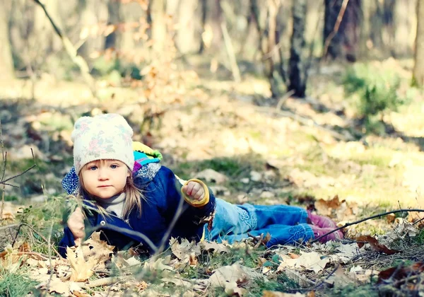 Menina deitada na grama na floresta — Fotografia de Stock