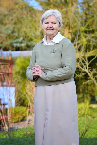 Старшая женщина улыбается и мечтает в саду . — стоковое фото