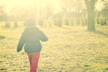 Güneş ışığında yürüyen çocuk.