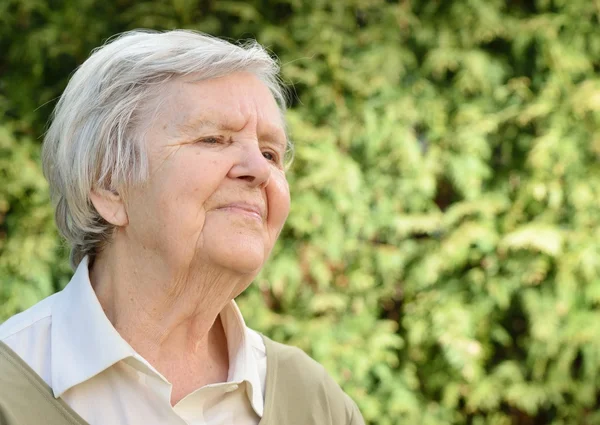 Glückliche Seniorin lächelt im Garten. — Stockfoto