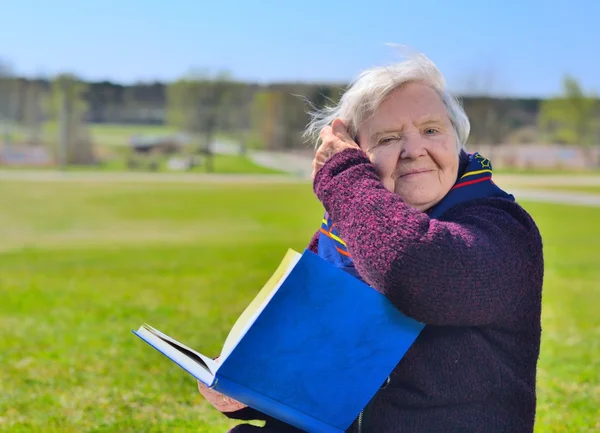 Seniorin liest Buch im Park lizenzfreie Stockfotos