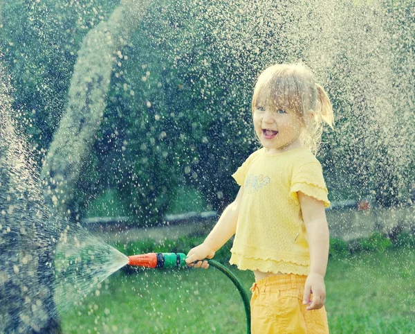 Kleines Mädchen spielt im Garten — Stockfoto