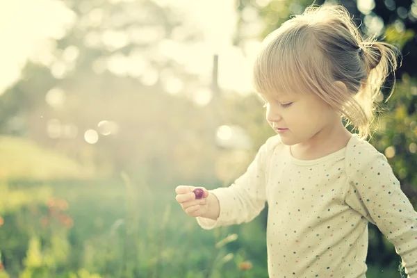Cute little girl playing outdoors — Stock Photo, Image