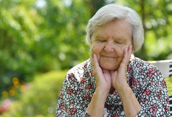 Старшая женщина мечтает в саду — стоковое фото