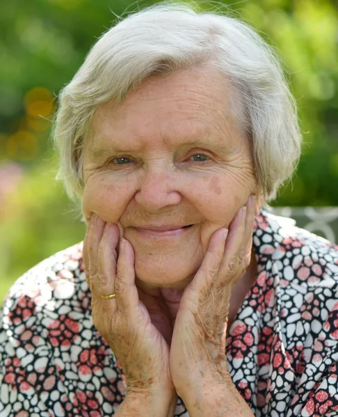 Senior woman dreaming in garden — Stock Photo, Image