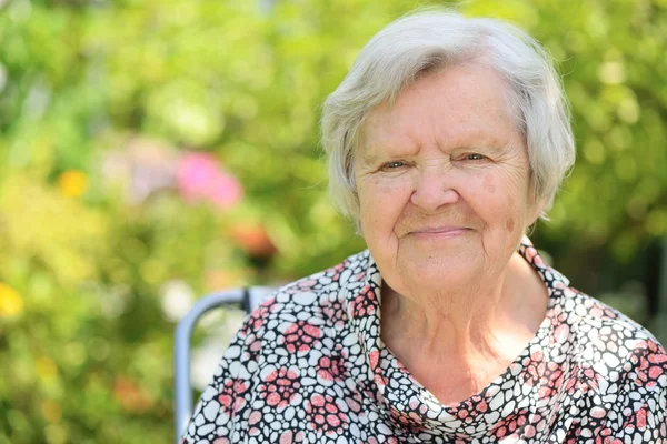 Seniorin träumt im Garten — Stockfoto